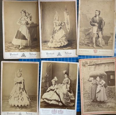 Six photographies anciennes représentant des femmes en robe et chapeau sont posées sur une table