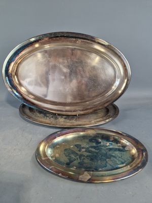 deux plateaux en argent posés l'un à côté de l'autre sur une table
