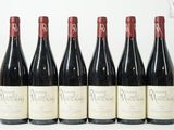six bouteilles de vin sont alignées sur une table