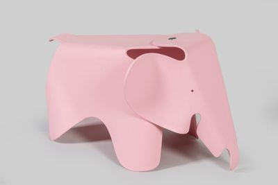 a small pink elephant that is sitting on a table