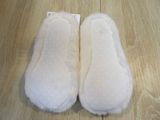 pair of white slippers sitting on top of a wooden floor