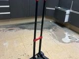 an image of a black and red dolly in a garage