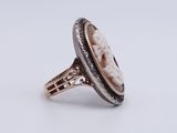 a white and black ring with a carved shell in the center