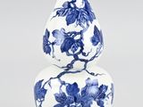 two blue and white vases sitting on top of each other on a table