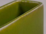 a close up of a green vase on a table