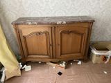 une armoire en bois avec un plateau en marbre, placée dans un coin de la pièce