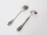 two spoons and a spoon on a white surface