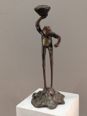 statue d'un homme tenant un bol, posée sur un socle