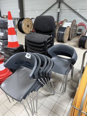 many chairs that are stacked up in a warehouse