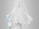 a close up of a chandelier with white flowers hanging from the ceiling