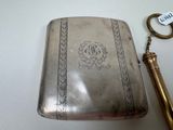 a silver case with a key and a keychain on a table