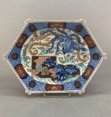un gros plan d'une assiette posée sur un socle et ornée d'un dragon