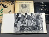 three books are sitting on a table next to a black and white photo