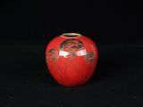 un vase rouge sur lequel est représentée une femme