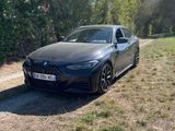 une voiture noire garée sur le bord d'un chemin de terre