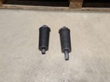 a pair of shock absorbs for a motorcycle on a concrete floor
