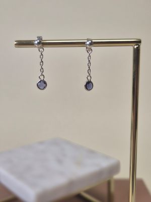 a pair of earrings that are hanging from a stand