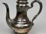 an antique silver tea pot with a handle and a lid