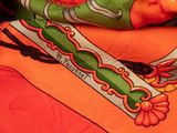 an orange scarf with a green and red design on it