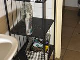 a bathroom with a toilet, sink, and shelf in it