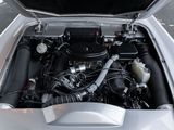a silver car with its hood open and the engine in the trunk