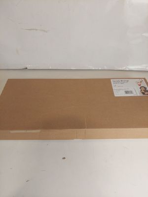 une boîte en carton posée par terre, sur laquelle est collé un autocollant
