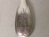 a spoon with a picture on it sitting on a table