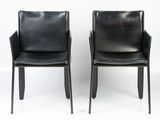 pair of black leather dining chairs with arms and legs