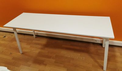 a white table that is sitting on a hard wood floor