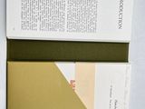 an open book sitting on top of a white table next to a book