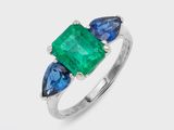 une bague sertie d'une émeraude et d'un saphir bleu sur fond blanc