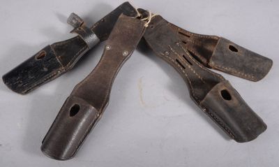 Plusieurs outils pour le cuir sont posés sur une surface blanche.