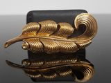 an image of a close up of a gold colored broochle on a table