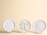 trois assiettes blanches ornées de motifs, disposées les unes à côté des autres