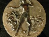 an image of a silver coin with a woman and a dog on it