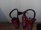 two fire extinguisors sitting next to each other on the floor