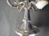 a silver candelab with a candle on top of it