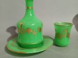 a green vase and a cup sitting on a table
