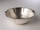 a silver bowl sitting on a table with a white background