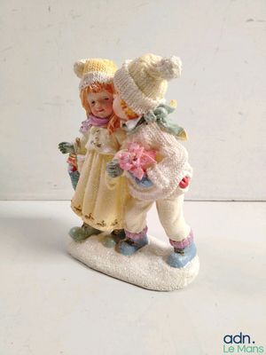 une petite figurine représentant une fille et un garçon sur un snowboard