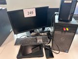 un ordinateur de bureau posé sur un bureau, à côté d'un écran et d'un clavier
