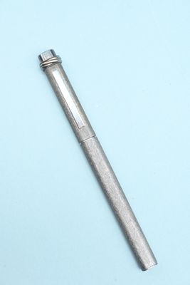 un stylo en métal posé sur une surface bleue