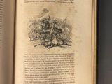 an open book on a table with a drawing of a man riding a horse