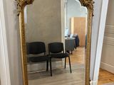 un grand miroir posé par terre à côté d'une chaise