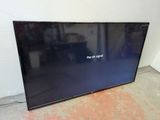 a large flat screen tv sitting on top of a floor next to a wall
