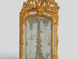 a mirror with a gold frame on a grey background