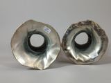 two silver vases sitting next to each other on a table