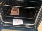 a person taking a picture of an oven with the door open