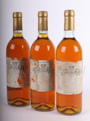 trois bouteilles de vin posées les unes à côté des autres sur une surface blanche
