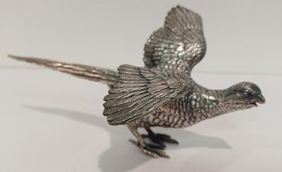 un oiseau argenté posé sur une surface blanche
